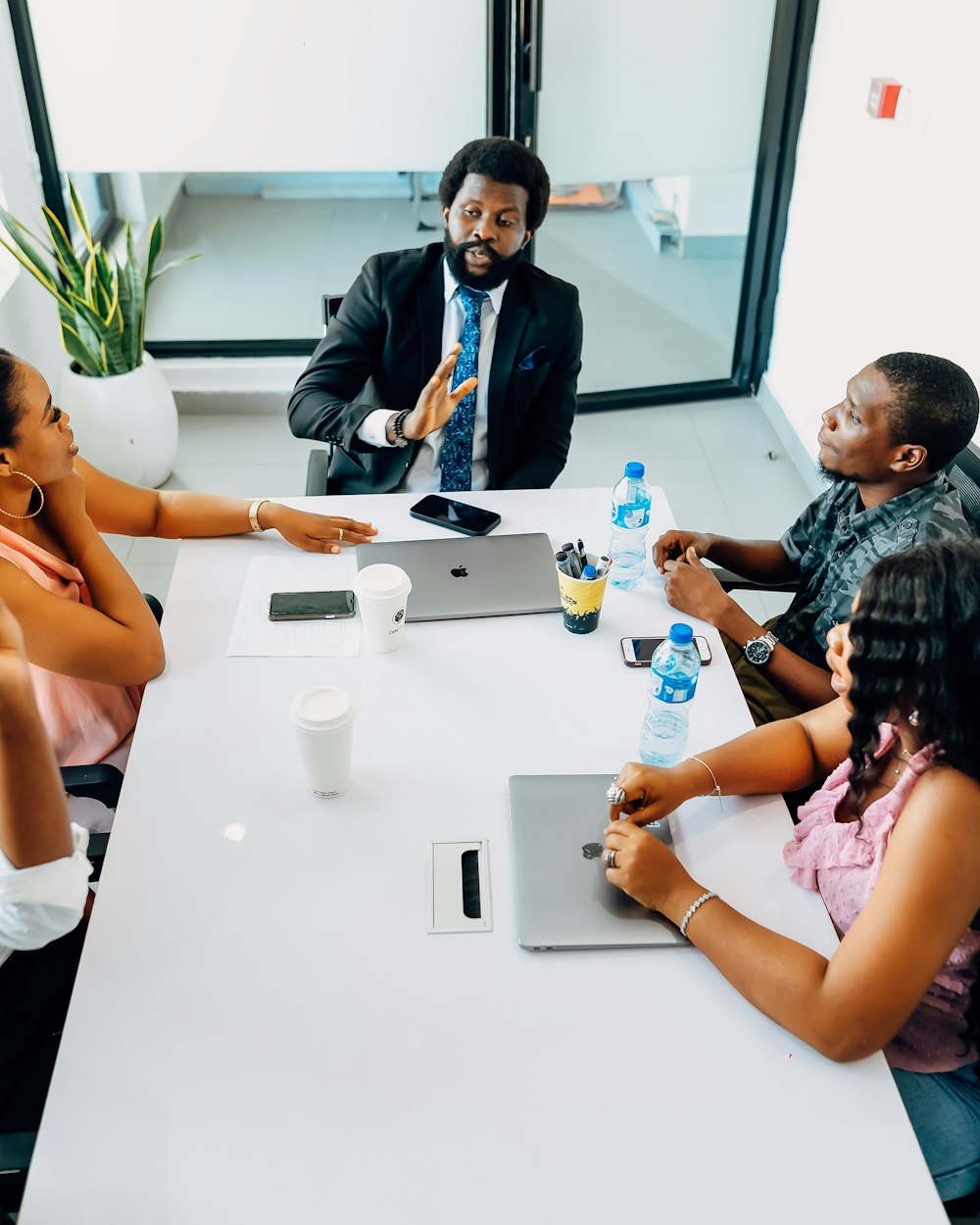 An executive leading a meeting around the boardroom table
