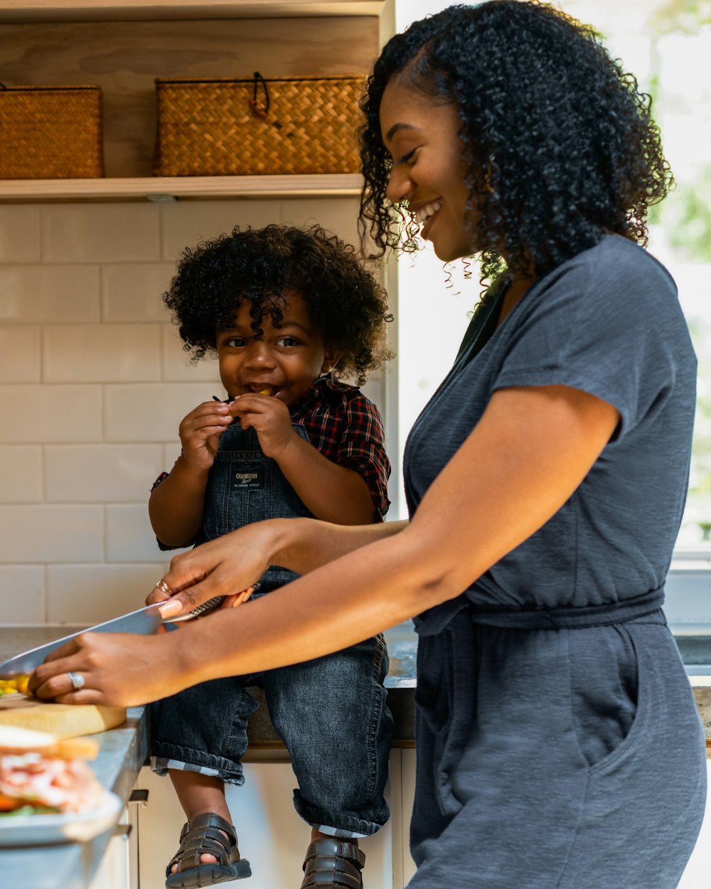 A mother cooking in the kitchen with her young son